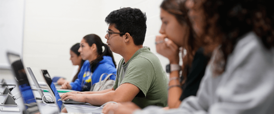 Students working on laptops on campus